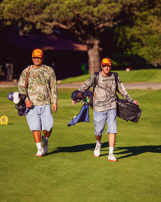 Two golfers walking a fairway with carry bags